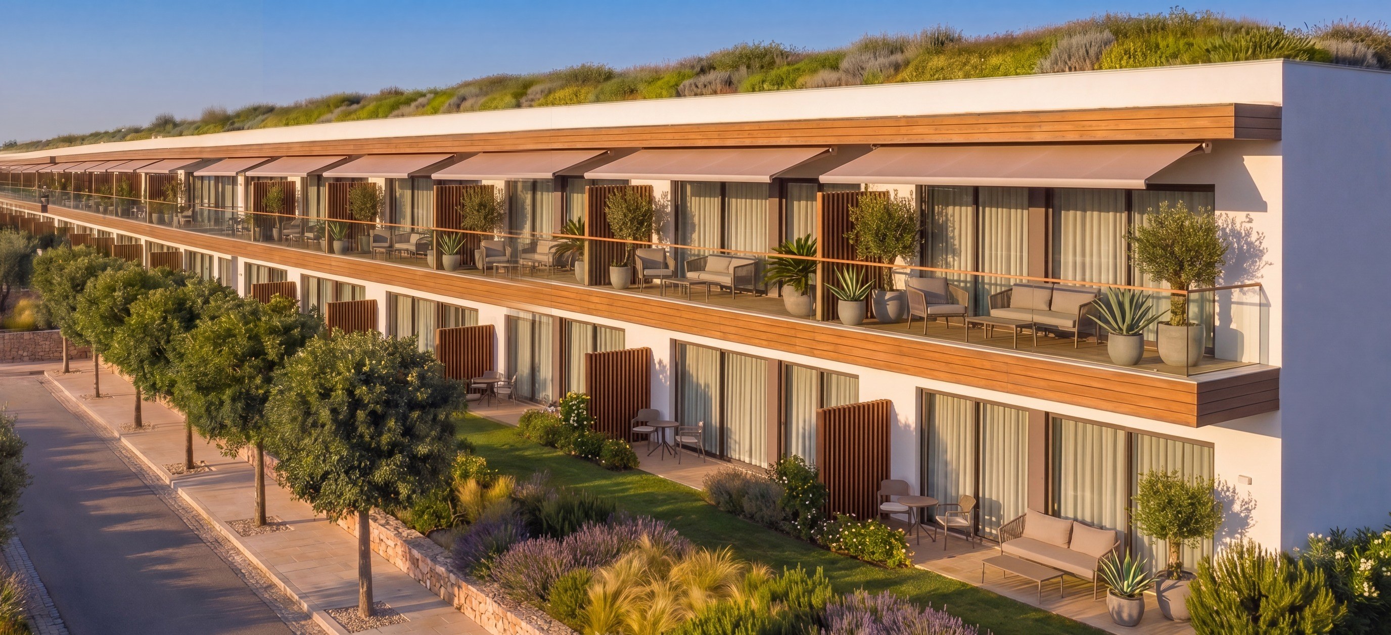 Apartment building with terraces and awnings, open lawn running to the communal pool