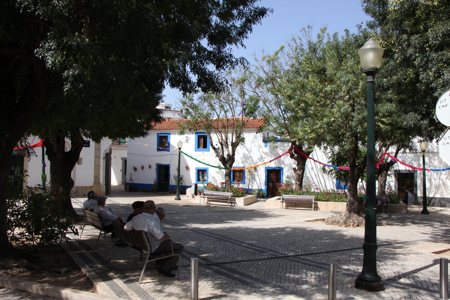 Shaded square in the center of Estoi with benches and old trees